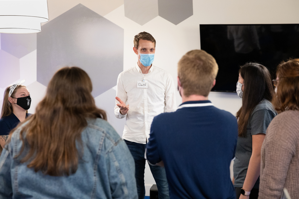 A professor works with Grad students who are mentoring Syracuse city high school students that are creating digital music in a program at Mercy Works.